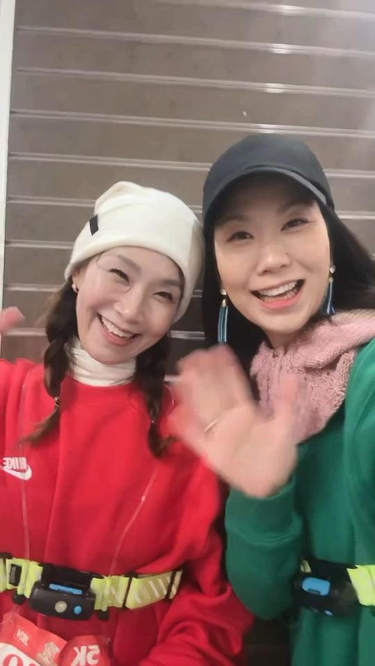 Esther Koh and Julie Kim, co-directors of PTL Treehouse, waving in winter running gear before a 5K